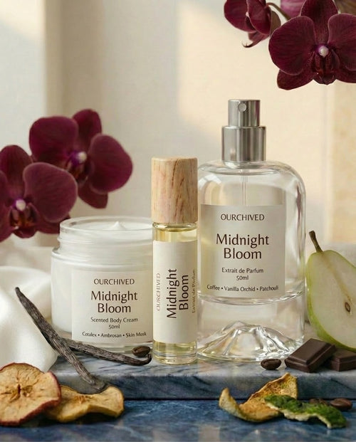 Ourchived Midnight Bloom products including a bottle, cream, and spray on a decorative surface with flowers and fruits.